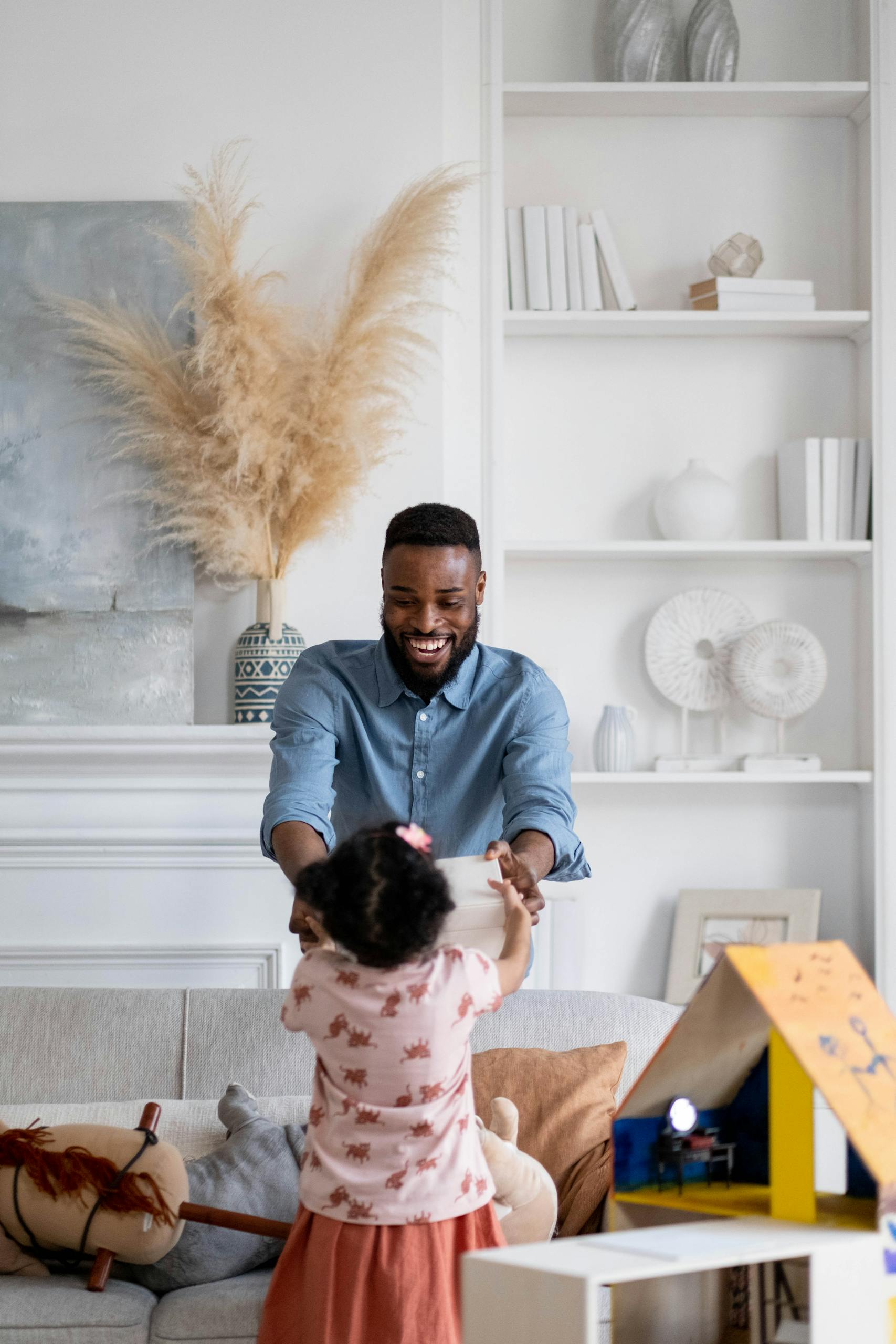Joyful father and daughter bonding indoors, playing together.
