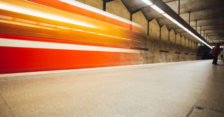 Long exposure of a subway train speeding through an underground station, capturing motion and energy.
